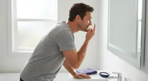 man with contact lenses in the bathroom mirror