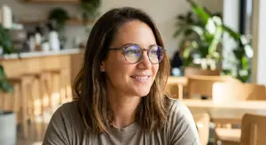 woman with eyeglasses in a coffee shop smiling
