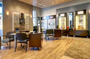 An image of an optical shop with desks, chairs, and sunglasses on display.