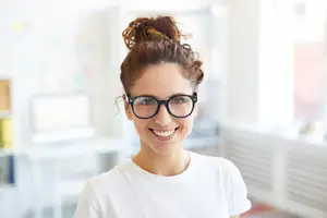 smiling woman in glasses inside an office
