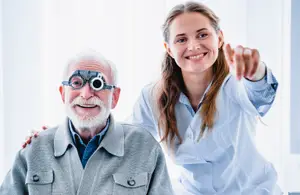 An elderly man and a young woman in lab coats standing close to each other in a room