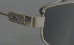Close-up of Quay sunglasses with the brand name Quay visible on the frame.
