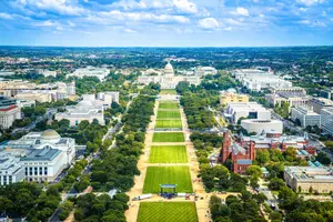 Aerial view of the National Mall in Washington D.C. featuring the Capitol building and multiple large buildings.