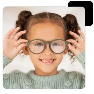 young girl with glasses smiling for the camera