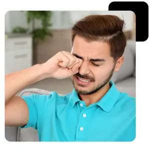 Man sneezing with a tissue in his hand.