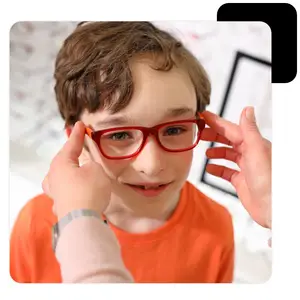 A young boy wearing glasses, a person is adjusting them for him