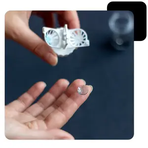 A hand holds a contact lens, preparing to insert it into the eye.