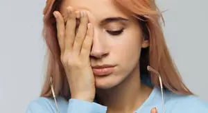 woman with glasses showing symptoms of a migraine