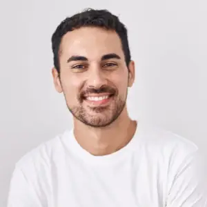 Man smiling and posing for a photo in a white shirt