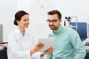 Doctor showing a tablet to a patient in a clinic