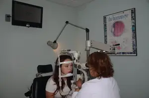 A woman is having an eye exam in a medical room