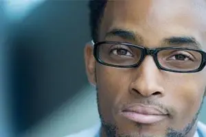 portrait of a man wearing glasses and a blue shirt