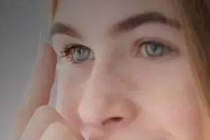 Close up of a woman smiling and touching her cheek with her finger