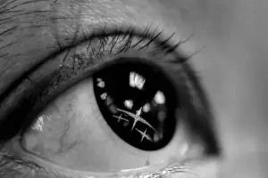 Close up of a person's eye with a cross reflection in the iris