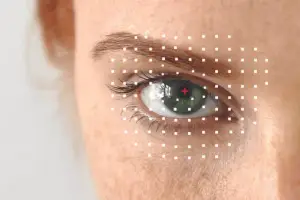 Close up of a woman's eye with a red cross and white dots on her skin