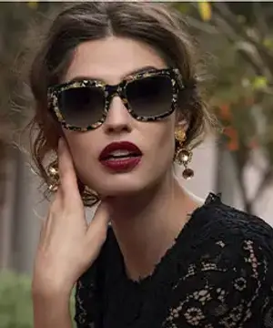A woman wearing sunglasses and a black lace dress