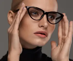 Close up of a woman in black turtleneck holding glasses