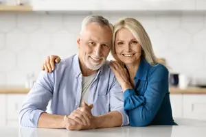A smiling older man and woman in a kitchen setting