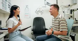 An eye doctor talks with a patient about their vision in an exam room