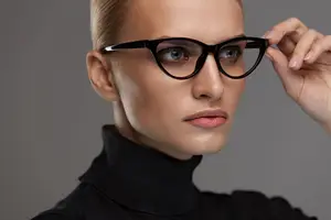 A woman wearing glasses and a turtleneck shirt.