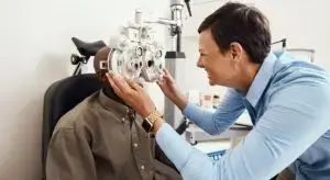 An adult male is having an eye exam with a doctor