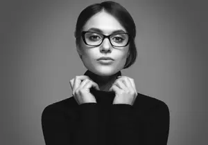 black and white portrait of a woman wearing glasses and a black turtleneck shirt