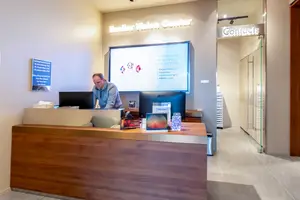 A man is working at the front desk of the Bausch and Lomb Vision Center in the Bausch and Lomb Building in Rochester, New York.