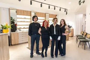 Four people in front of a store smiling for the camera