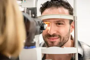 Man having his eyes examined by a doctor with a slit lamp