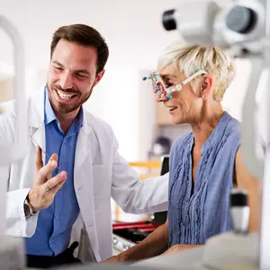 Doctor examining patient's eye using a slit lamp