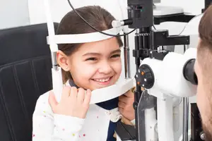 A girl smiling undergoing an eye exam