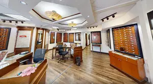 A room with wooden floors, a ceiling with lamps, and furniture such as chairs and tables.