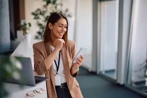 Businesswoman holding a tablet in an office room with a glass wall