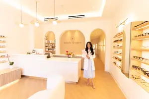 Optometrist greeting patient at front desk at Maison De Vision Eye Care Studio