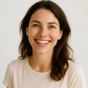 A smiling woman with brown hair wearing a beige shirt looking straight ahead