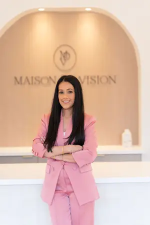 Woman standing in front of a Maison Vision sign