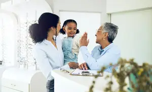 optometrist talking with mom and daughter
