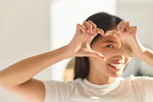 Eye Care. Woman Framing Eye With Heart-Shaped Hands, Symbolizing Love And Positivity, Eye Health.