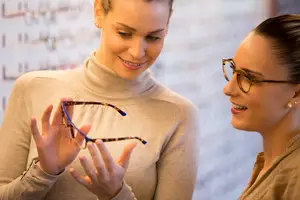 Two women in a optical boutique looking at glasses