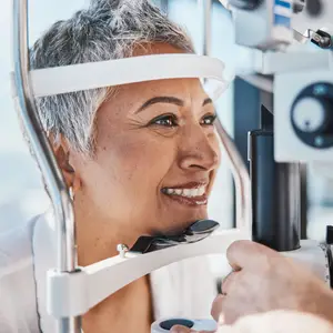 A woman with gray hair undergoing an eye exam