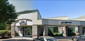 Exterior view of All Family Eye Care in Eugene, Oregon, featuring a modern building with glass doors and a sign reading 'All Family Eye Care', accompanied by parked cars and greenery.