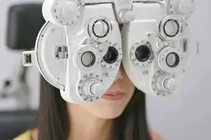 Woman using an ophthalmoscope to check her eyes.