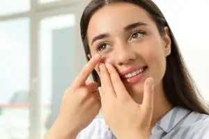 Woman inserting contact lens into her eye