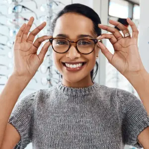 woman adjusting glasses and smiling