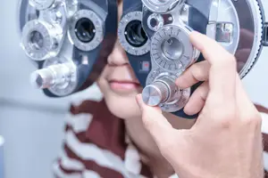 Optometrist adjusting a phoropter in an optometrist's office