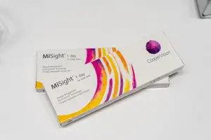 Two boxes of MiSight 1 Day contact lenses by CooperVision on a white surface.