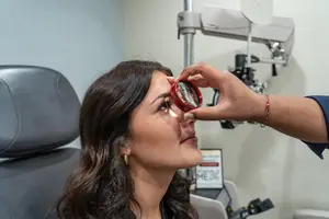 A woman is having her eyes examined in a medical setting.