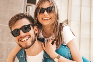 A man and a girl wearing sunglasses and smiling for a photo