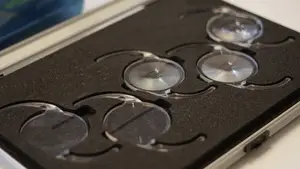 Three clear glass circular objects in a black case