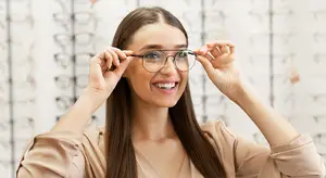 A smiling woman with glasses in a photo studio